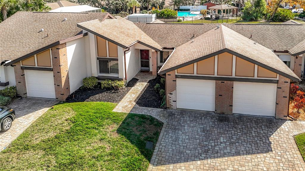 An exterior view of a multi-unit residential building with brick accents and paved driveways — 7385 CRESTWOOD DRIVE, WEEKI WACHEE, FL