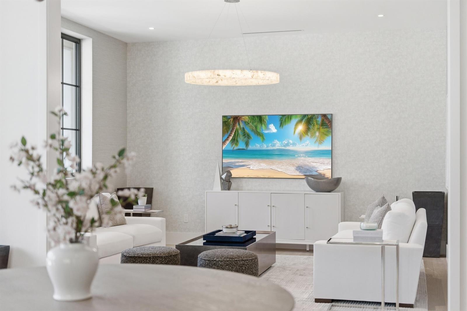 A bright living room features white sofas, a central coffee table, and a wall-mounted television — 210 Cortez Road, West Palm Beach FL 33405, WEST PALM BEACH, FL