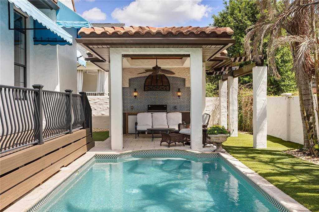 A backyard pool area features a covered patio with outdoor seating and a tiled wall — 1398 GROVE TERRACE, WINTER PARK, FL