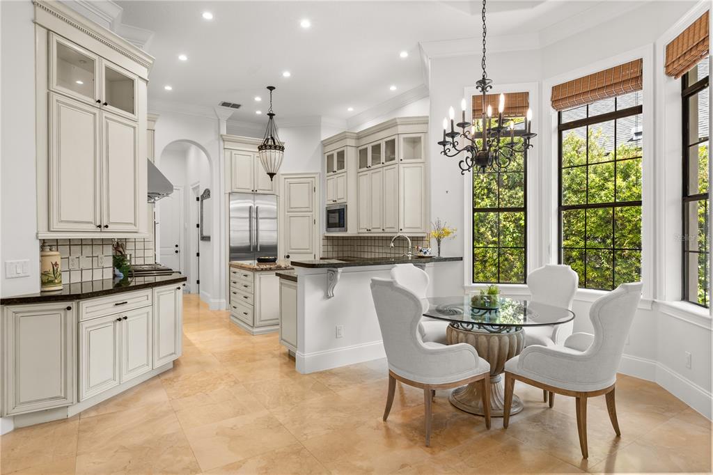 A kitchen with white cabinetry, dark countertops, tile flooring, and a breakfast nook with chairs — 1398 GROVE TERRACE, WINTER PARK, FL