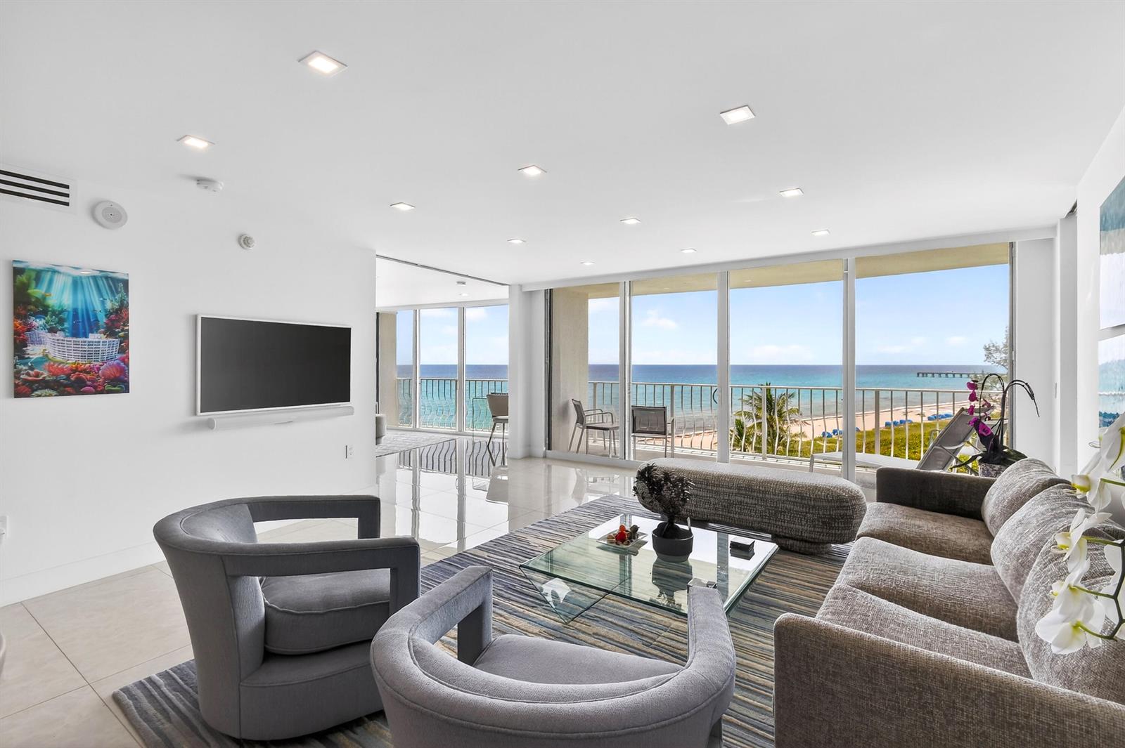A living room with gray furniture, a glass coffee table, and floor-to-ceiling ocean views — 2774 S Ocean Boulevard # 704, Palm Beach FL 33480, PALM BEACH, FL