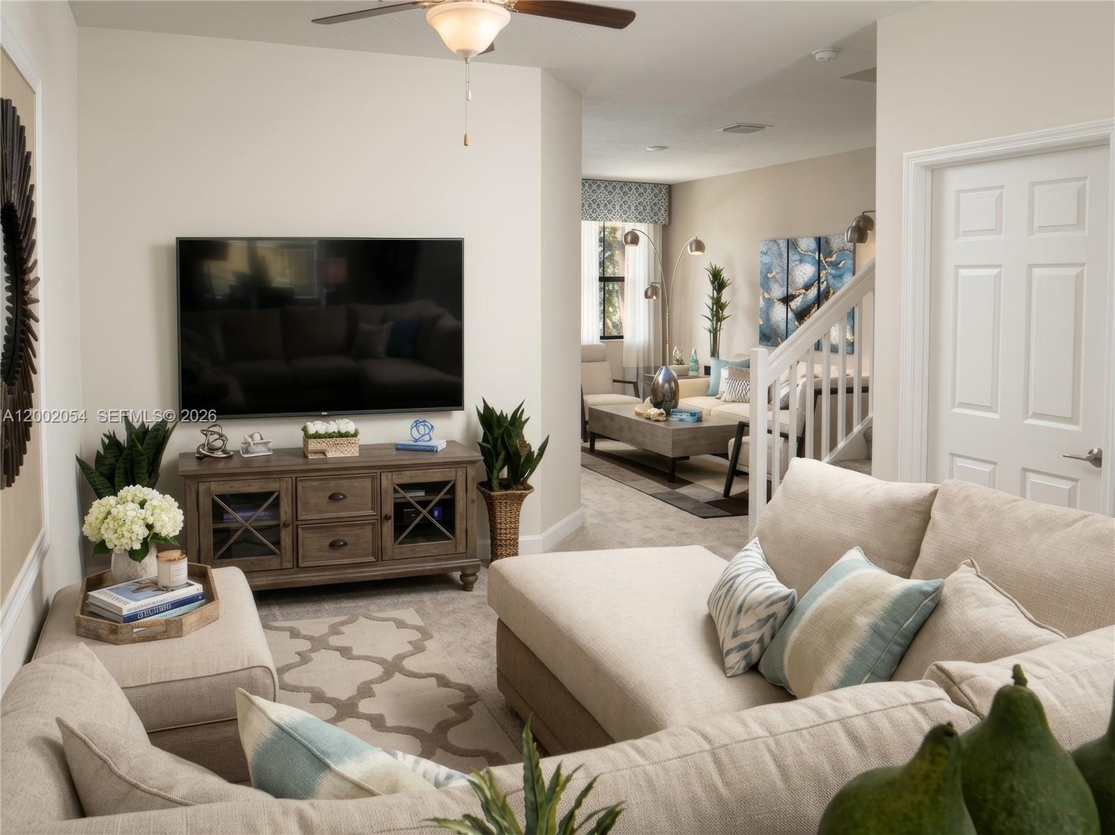 A living room features a wall-mounted television, a wooden media console, and a sectional sofa — 12525 NW 23rd Pl, Miami FL 33167, MIAMI, FL
