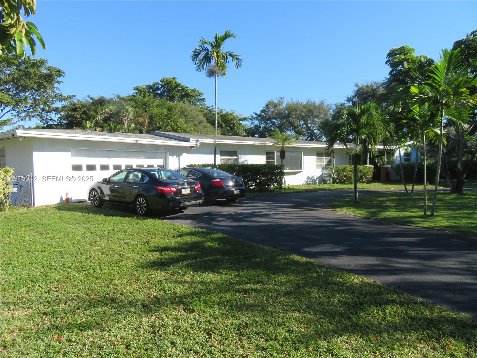 A white single-story house with a two-car garage and a paved driveway — 7955 SW 131st St, Pinecrest FL 33156, PINECREST, FL
