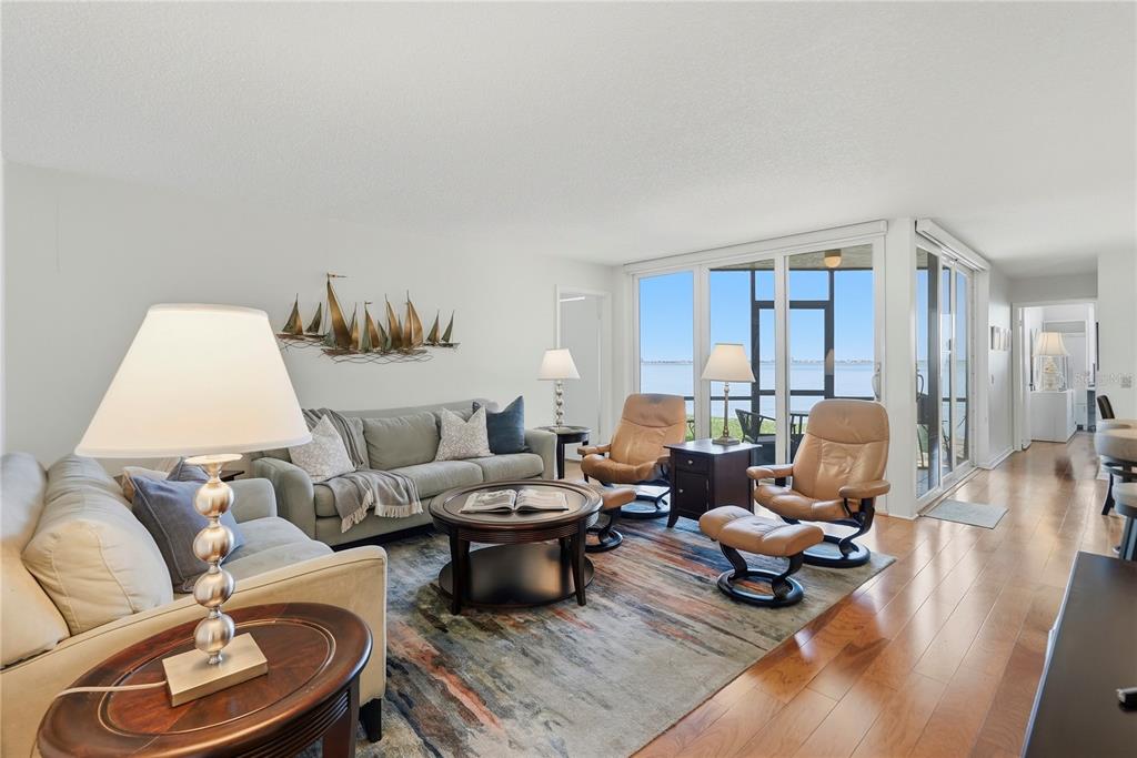 A living room features a sofa, two leather recliners, a coffee table, and large sliding glass doors — 5729 PUERTA DEL SOL BOULEVARD S UNIT 181, ST PETERSBURG, FL