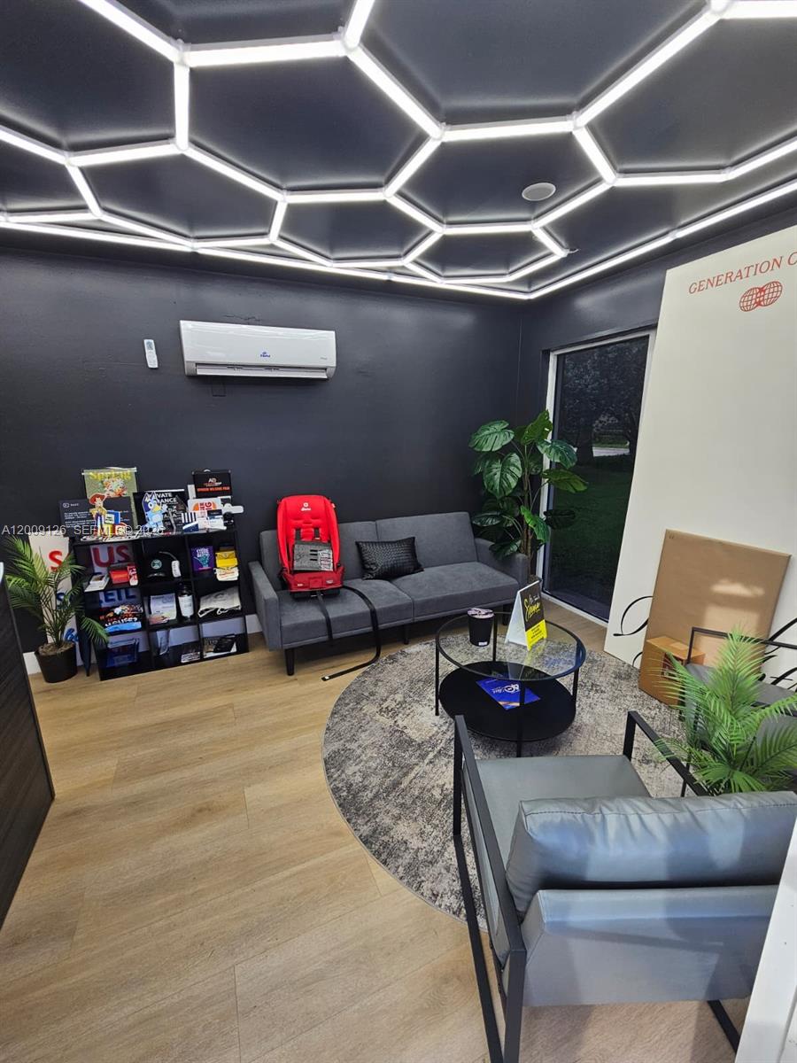 A modern office space features a hexagonal LED ceiling, gray sofa, and wood-look flooring — 13850 SW 143rd Ct # 14, Miami FL 33186, MIAMI, FL
