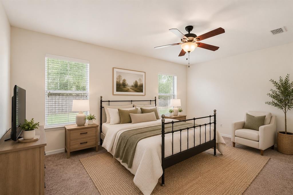 A bedroom features a black metal bed frame, a ceiling fan, and two bedside tables — 12104 NW 162ND DRIVE, ALACHUA, FL