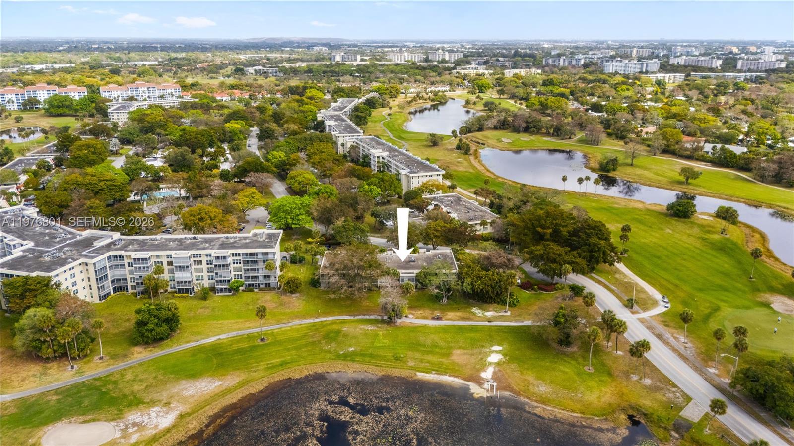 An aerial view shows a multi-story apartment building surrounded by green space and lakes — 823 Cypress Blvd # 204, Pompano Beach FL 33069, POMPANO BEACH, FL