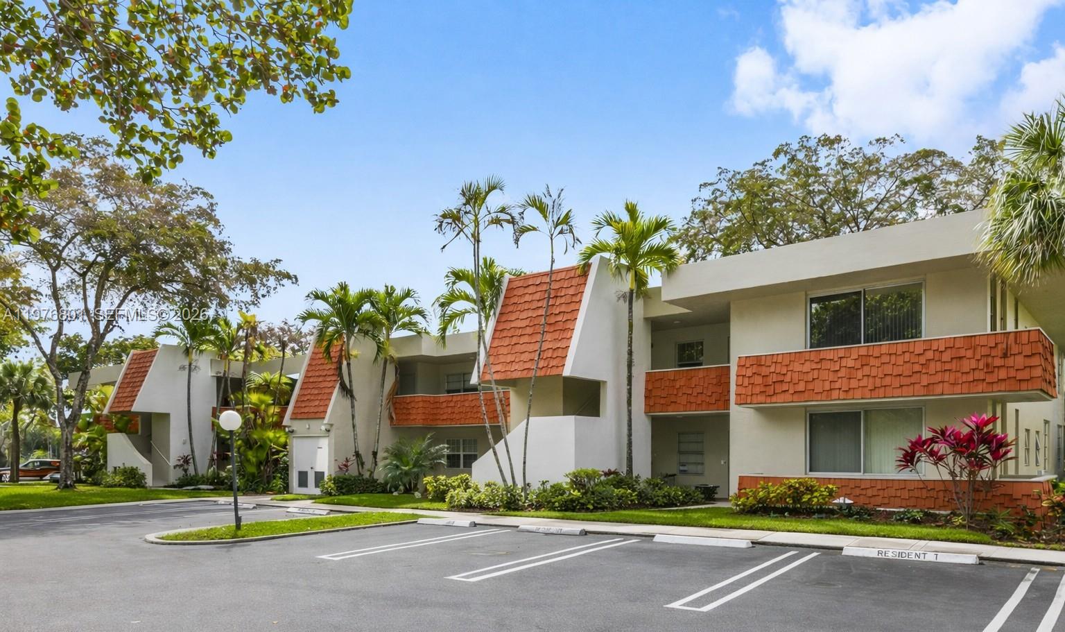 A low-rise apartment building with white walls, orange shingled accents, and a parking lot — 823 Cypress Blvd # 204, Pompano Beach FL 33069, POMPANO BEACH, FL