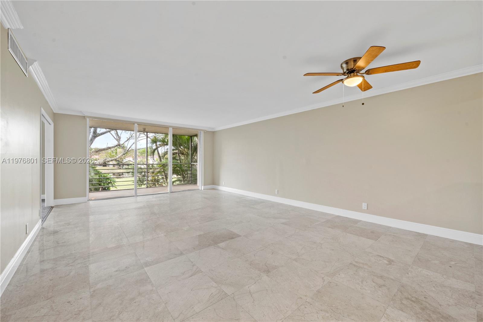A spacious living room features light-colored tile flooring, beige walls, and a ceiling fan — 823 Cypress Blvd # 204, Pompano Beach FL 33069, POMPANO BEACH, FL