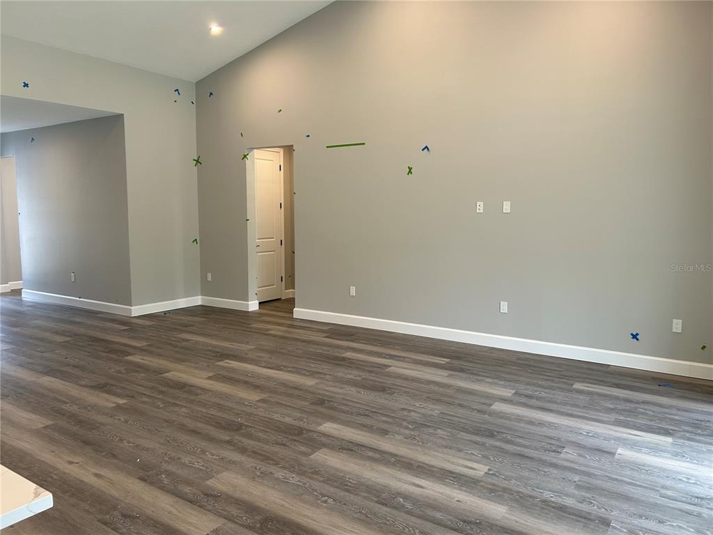 A spacious living room features light gray walls, high vaulted ceilings, and wood-look vinyl flooring — 3064 W PINE RIDGE BOULEVARD, BEVERLY HILLS, FL
