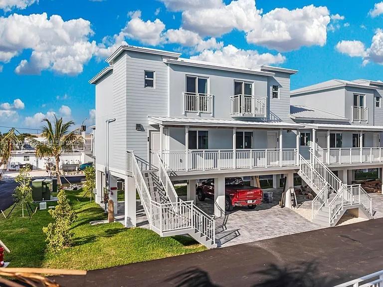 A two-story light blue house with an elevated main floor and a covered parking area — 10877 Overseas Hwy # 37, Marathon FL 33050, MARATHON, FL