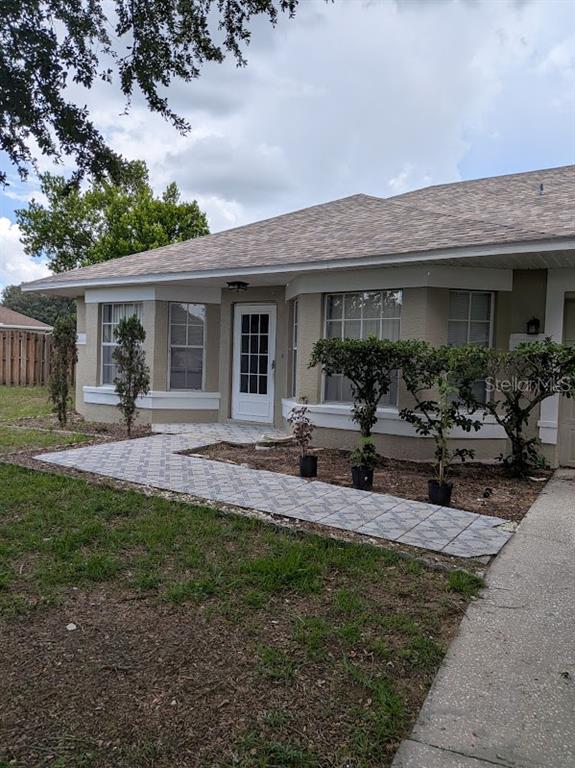 A single-story house exterior features a paved walkway leading to a white front door — 7885 CAMLYN COURT, ORLANDO, FL