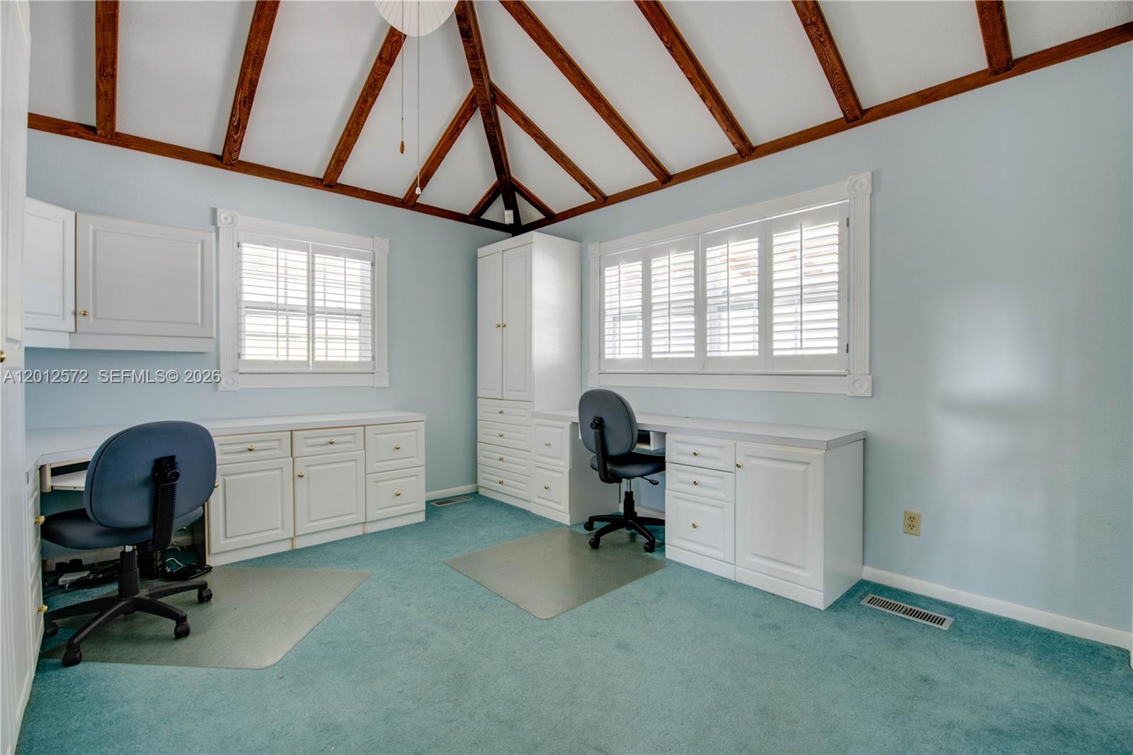A home office features built-in white cabinetry, blue carpeting, and a vaulted wood-beamed ceiling — 29662 Independence Ave, Big Pine FL 33043, BIG PINE, FL