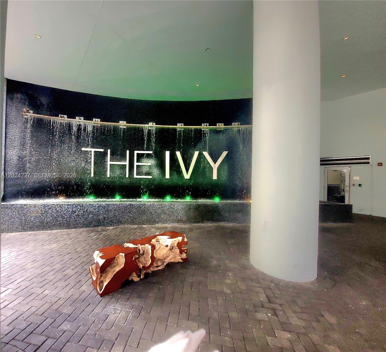 A lobby entrance features a water wall with the name The Ivy and a wooden bench — 90 SW 3rd St # 2208, Miami FL 33130, MIAMI, FL