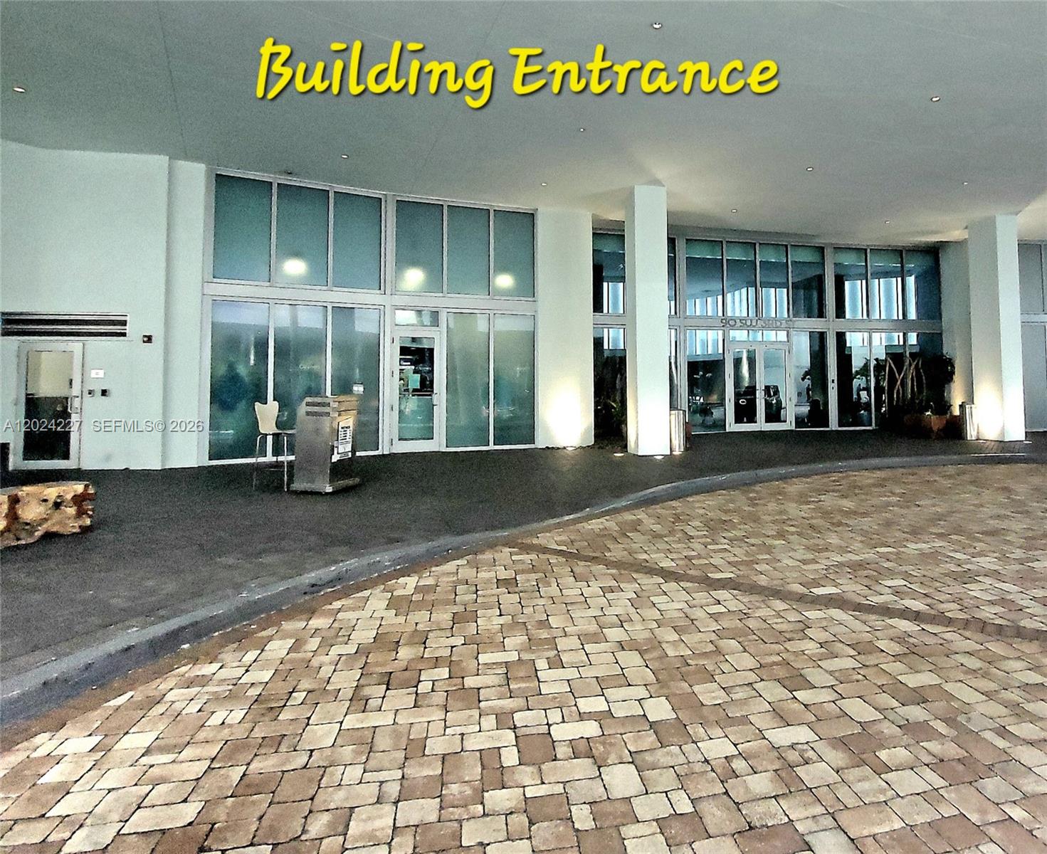 The building entrance features a paved circular driveway and glass-paneled doors under a large overhang — 90 SW 3rd St # 2208, Miami FL 33130, MIAMI, FL