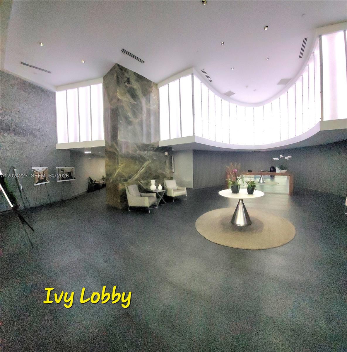 The spacious lobby features a large marble pillar, curved walls, and a central round table — 90 SW 3rd St # 2208, Miami FL 33130, MIAMI, FL