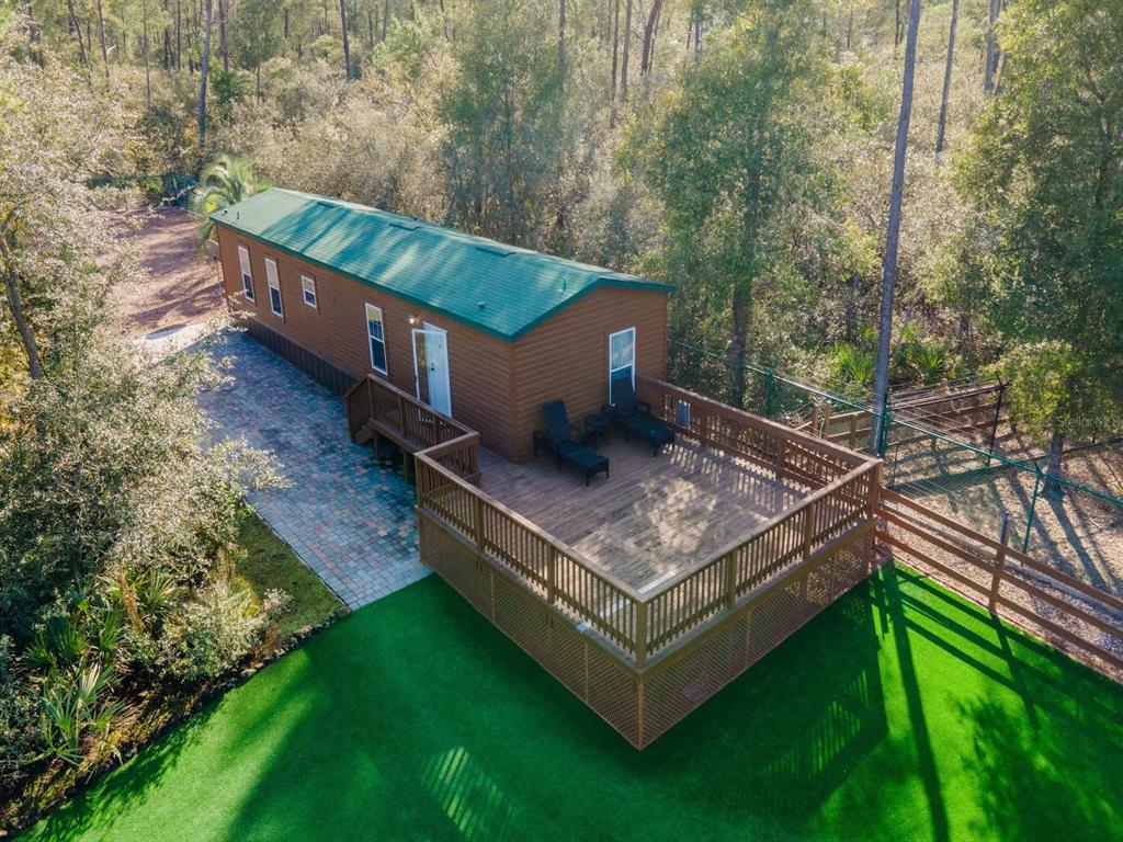 An aerial view shows a mobile home with a green roof and a large wooden deck — 5600 NE NFR 5, SILVER SPRINGS, FL