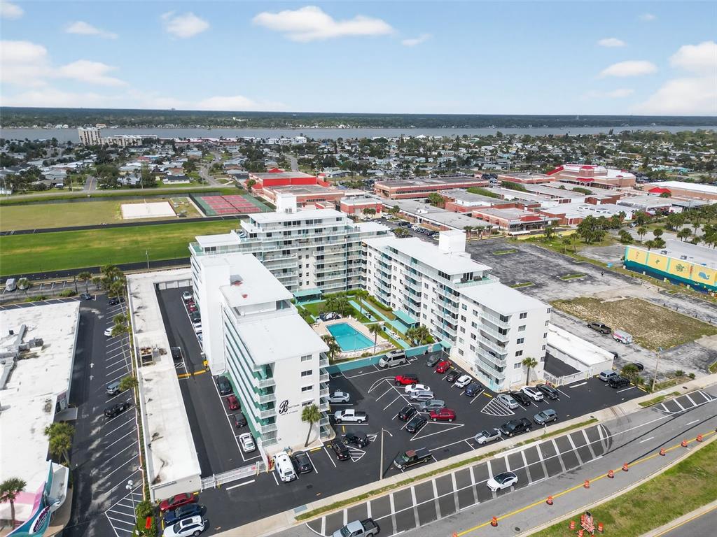 An aerial view shows a multi-story apartment complex with a central swimming pool and parking — 2727 N ATLANTIC AVENUE UNIT 3170, DAYTONA BEACH, FL