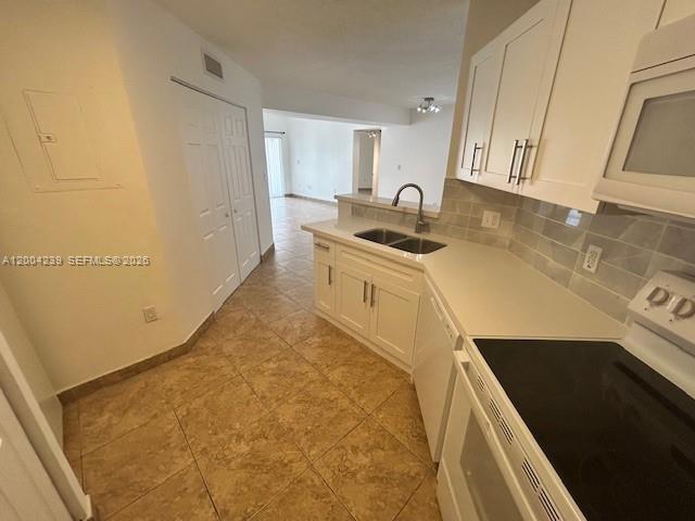 A kitchen features white cabinets, light countertops, a double sink, and tiled flooring — 6292 NW 186th St # 306, Hialeah FL 33015, HIALEAH, FL