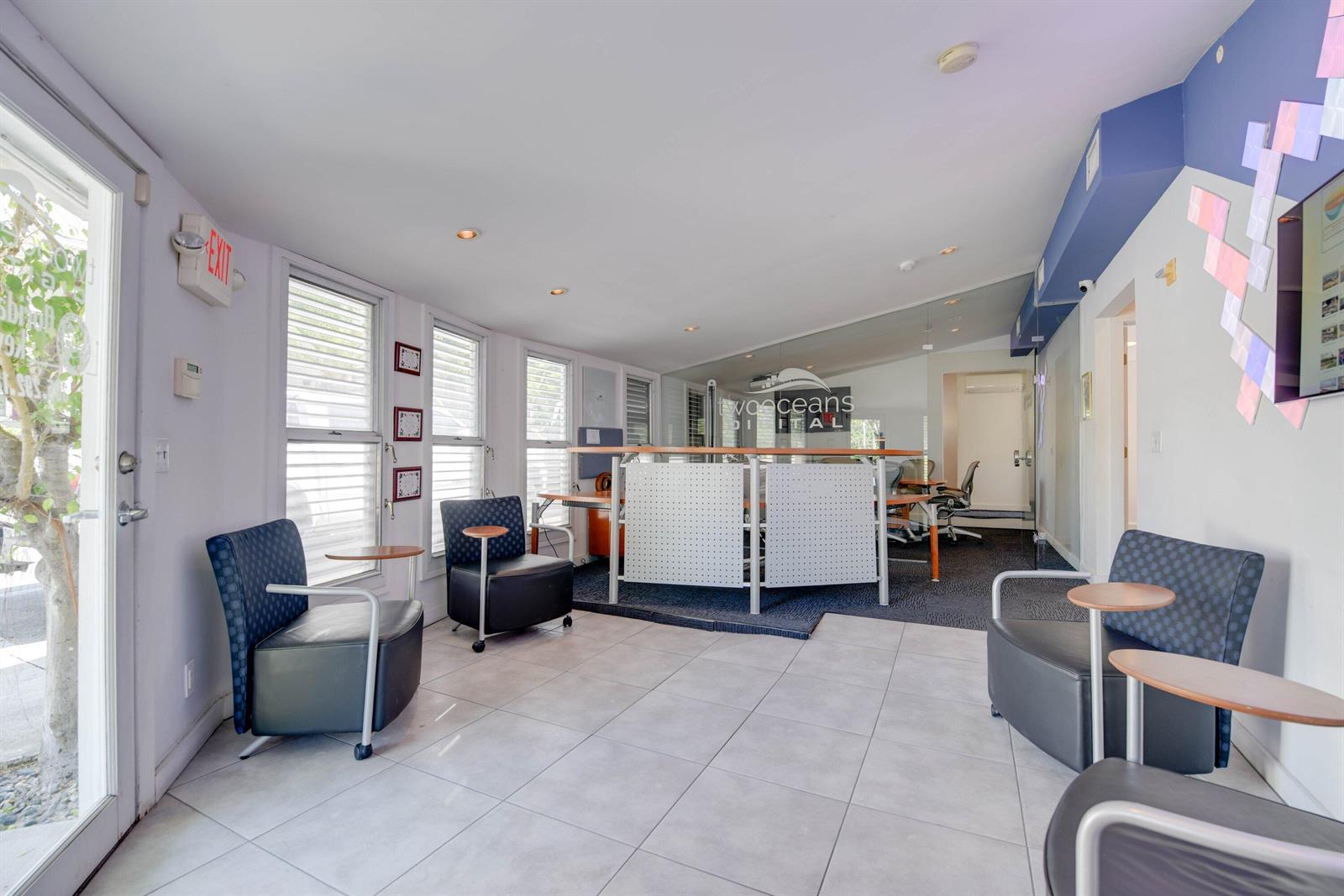 A waiting area with tiled floors, three chairs with side tables, and a glass-partitioned office — 701 Simonton Street, Key West FL 33040, KEY WEST, FL