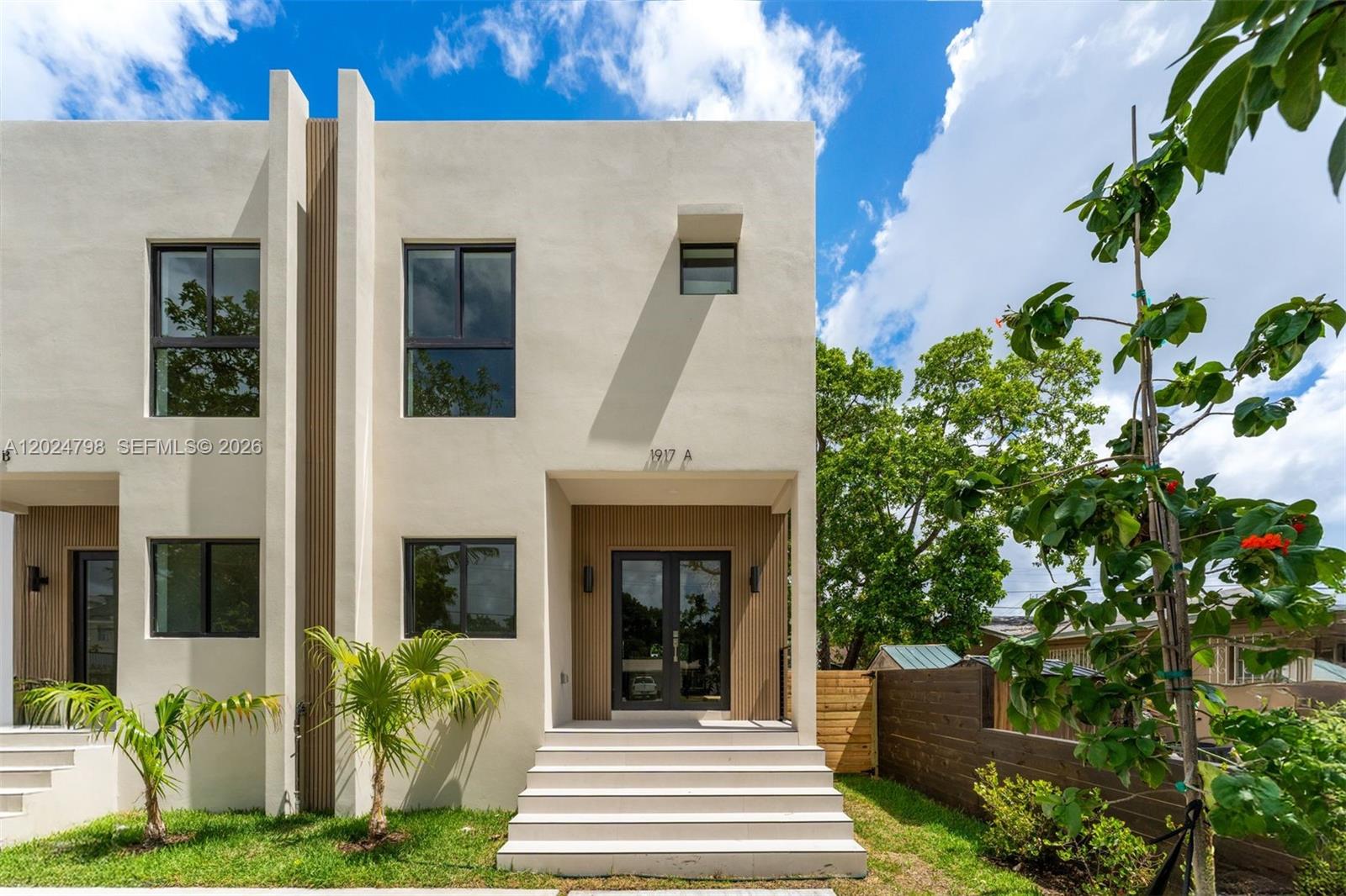 The exterior of a modern two-story townhouse features light stucco walls and a recessed entrance — 1917 NW 17 ST # A, Miami FL 33125, MIAMI, FL