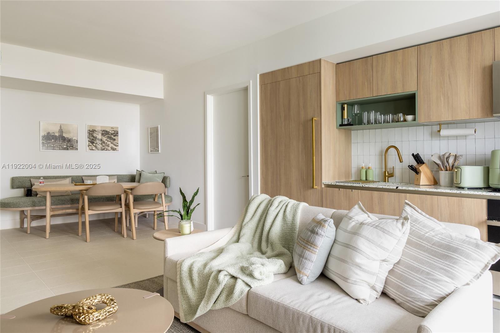 This open-concept living area features a kitchen with wood cabinetry and a dining nook — 159 NE 6th St # 3002, Miami FL 33132, MIAMI, FL
