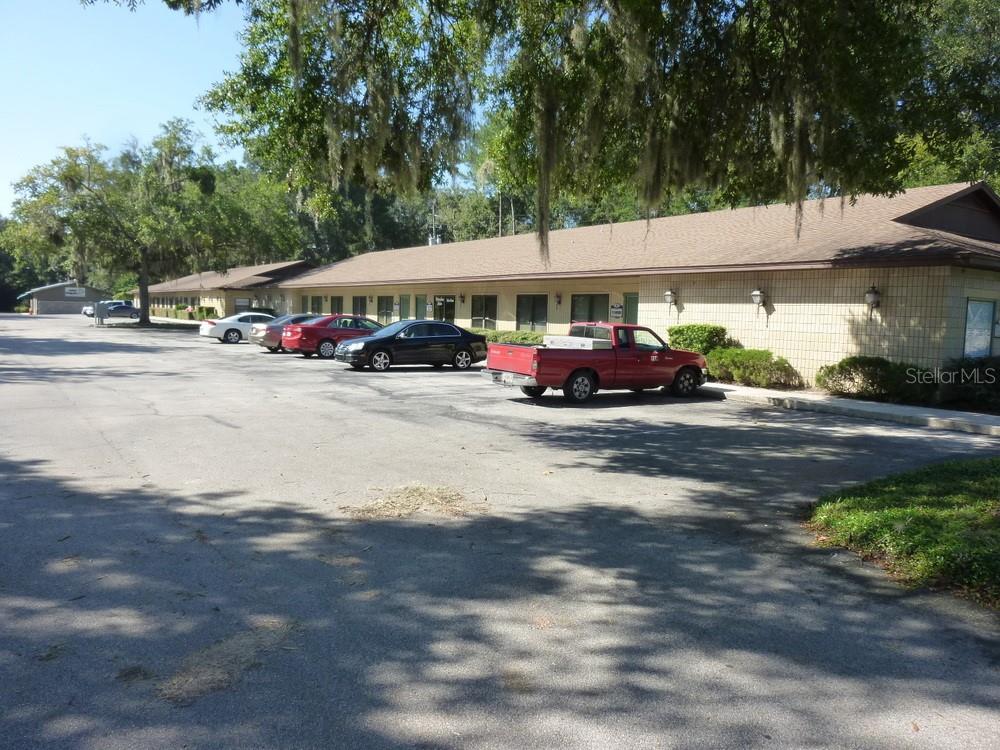 A single-story commercial building with a parking lot and several parked vehicles — 4509 NW 23RD AVENUE UNIT 19A, GAINESVILLE, FL