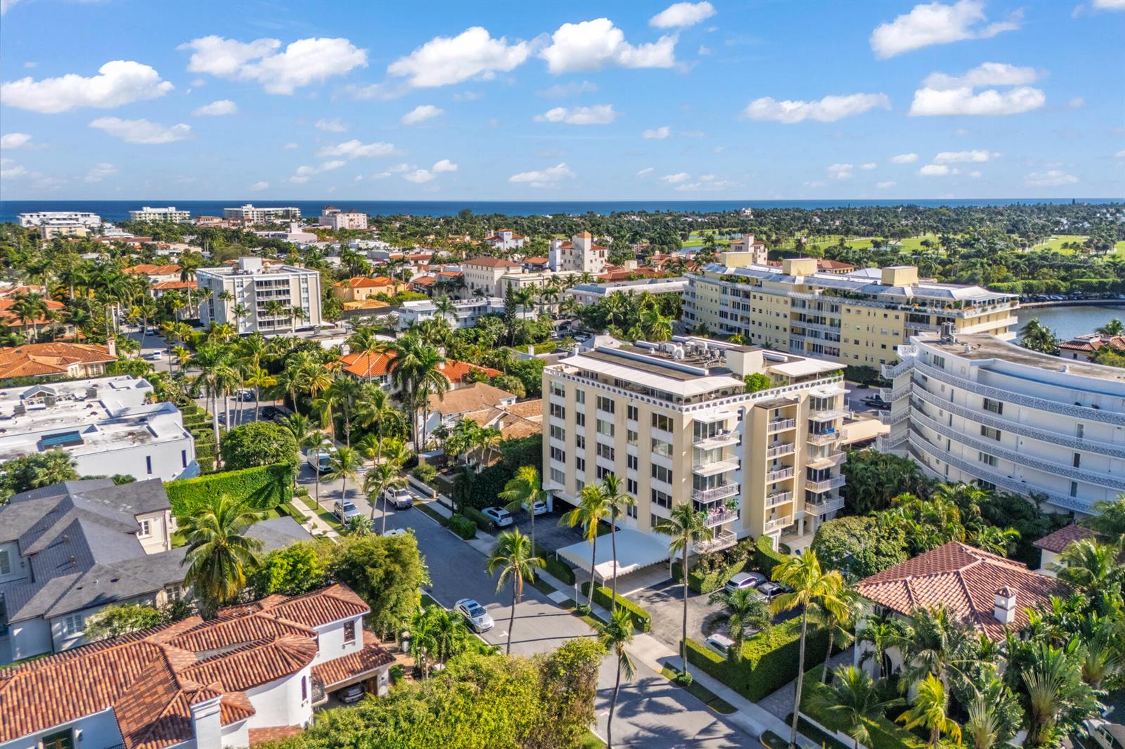 A swimming pool sits on a patio next to a multi-story building with balconies — 434 Chilean Avenue # 2b, Palm Beach FL 33480, PALM BEACH, FL