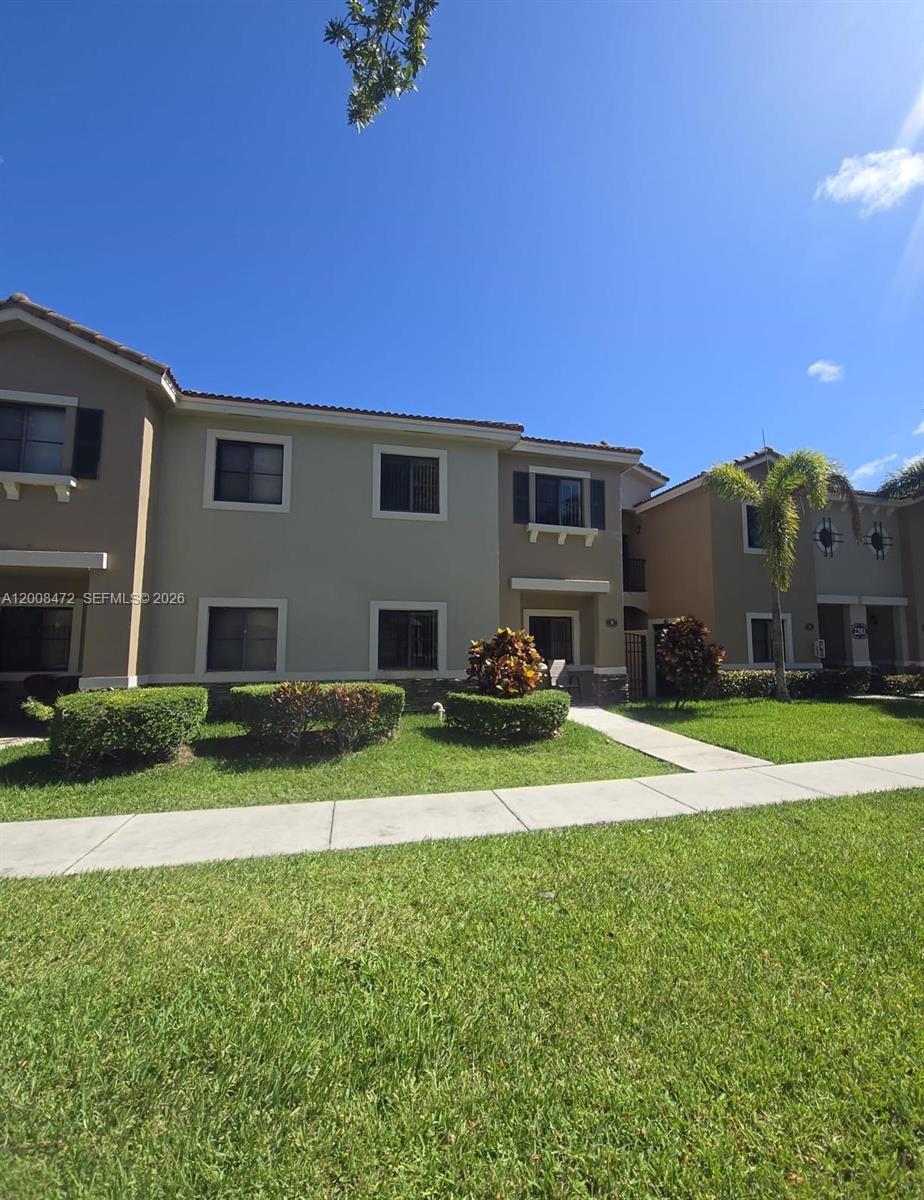 A two-story apartment building exterior with a lawn, sidewalk, and landscaping under a blue sky — 22911 SW 88th Pl # 21, Cutler Bay FL 33190, CUTLER BAY, FL