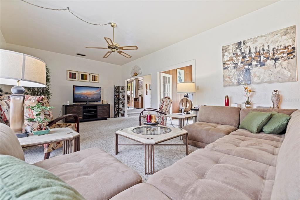 A living room features a large sectional sofa, a coffee table, and a ceiling fan — 726 17TH AVENUE S, ST PETERSBURG, FL