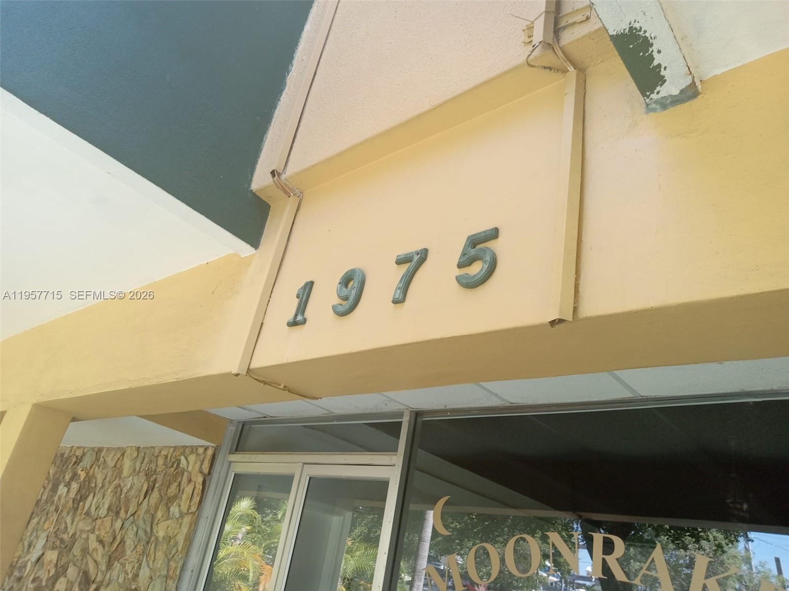 The exterior of a building features the number 1975 mounted on a beige wall — 1975 NE 135th St # 3C, North Miami FL 33181, NORTH MIAMI, FL