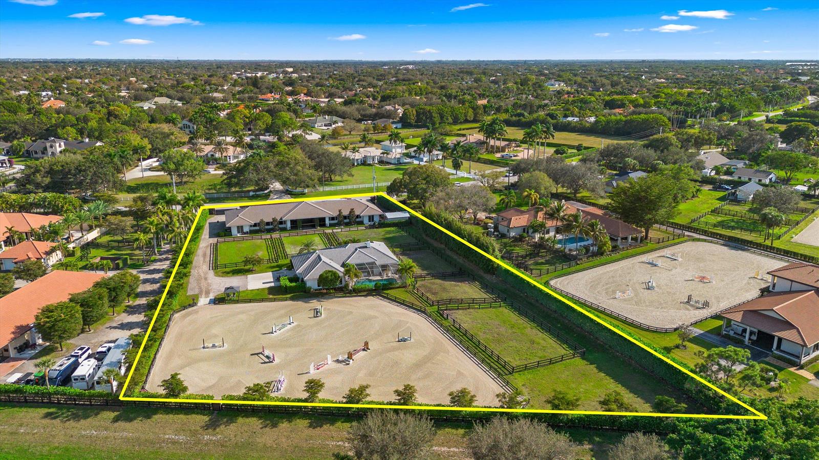 An aerial view of a residential equestrian property featuring a house, barn, and riding arena — 14371 Wellington Trace, Wellington FL 33414, WELLINGTON, FL