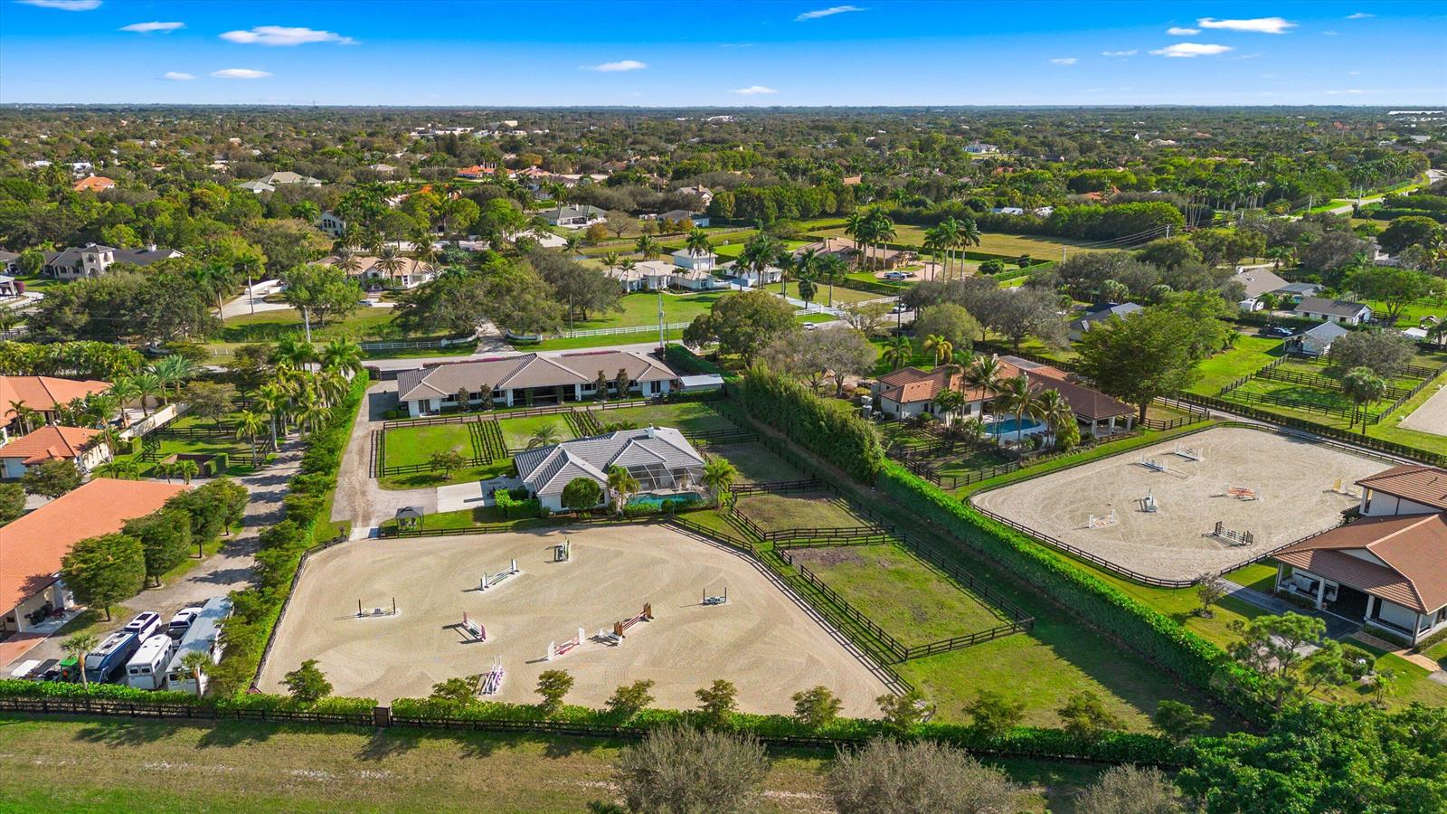An aerial view shows a residential property featuring two riding arenas, stables, and swimming pools — 14371 Wellington Trace, Wellington FL 33414, WELLINGTON, FL