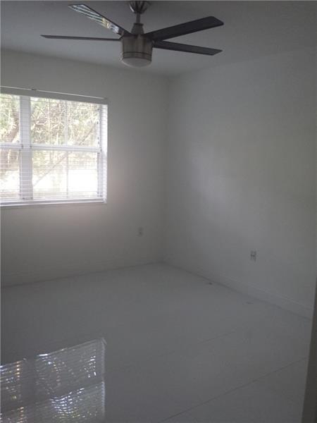 An empty bedroom features white walls, tile flooring, a ceiling fan, and a single window — 2451 E Centergate Drive # 208, Miramar FL 33025, MIRAMAR, FL