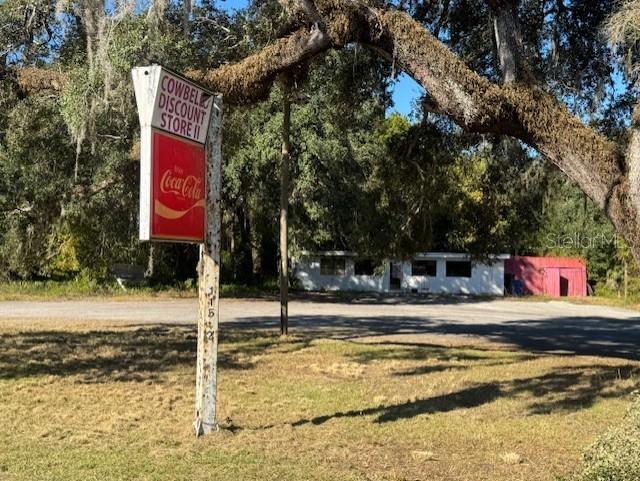 A weathered sign for a discount store stands in front of a small, rural building — 11542 S US HIGHWAY 301, WEBSTER, FL