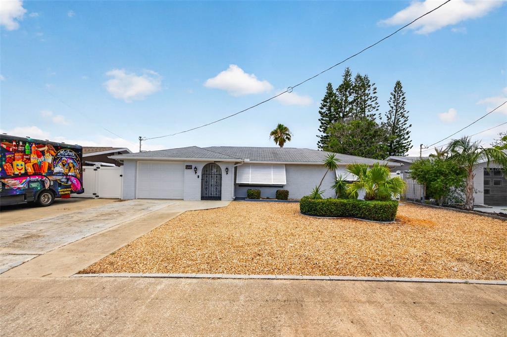 A living room features a beige sofa, armchair, coffee table, and a large area rug — 13626 JENNITA DRIVE, HUDSON, FL