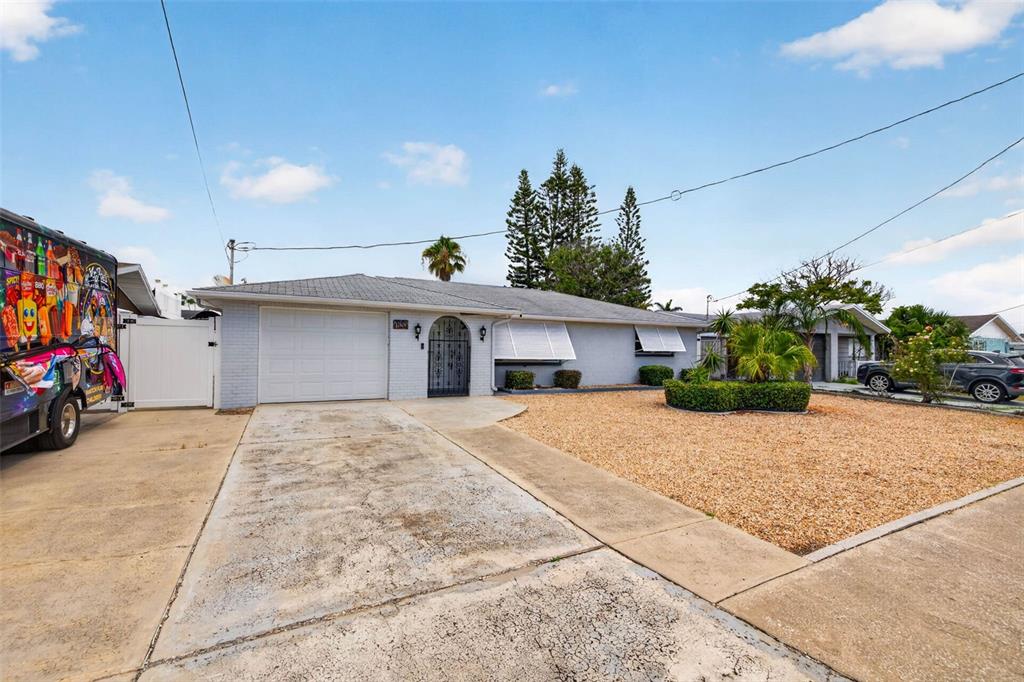 An empty room with beige carpet, light walls, a window with blinds, and a white door — 13626 JENNITA DRIVE, HUDSON, FL