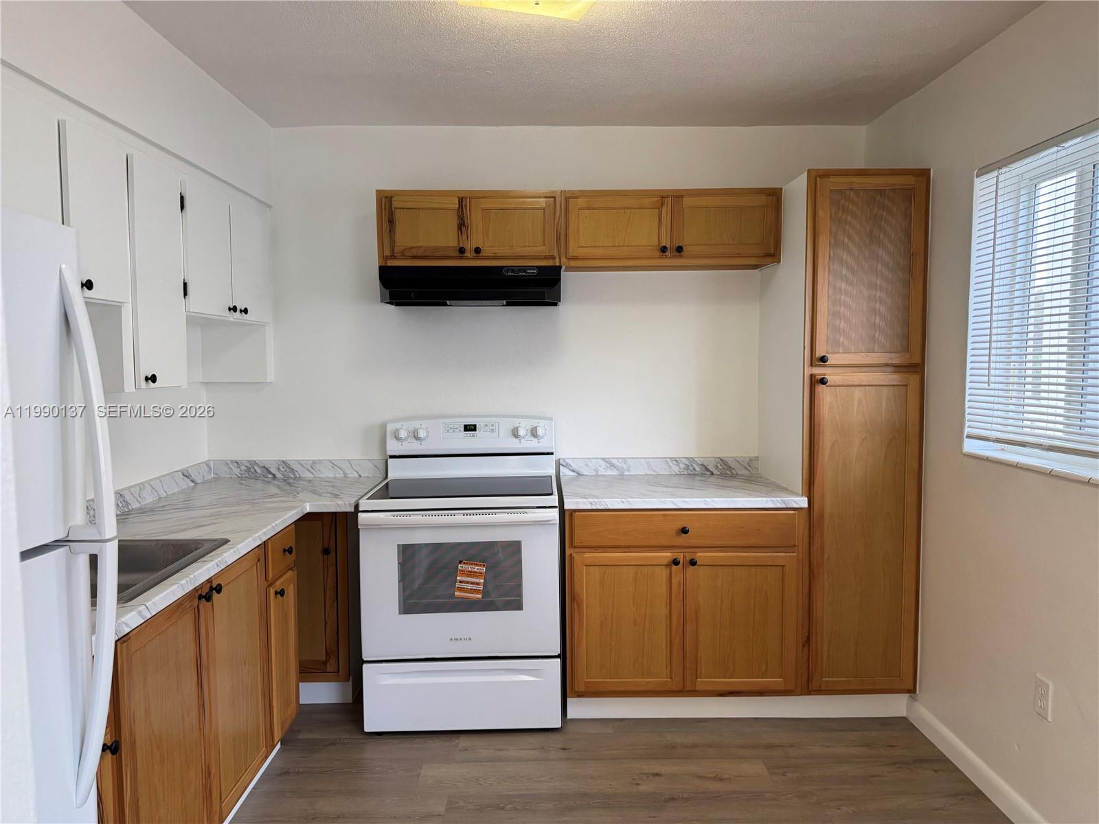 A kitchen features wood cabinets, white appliances, and marble-patterned countertops — 4080 SW 2nd Ter # 6, Miami FL 33134, MIAMI, FL