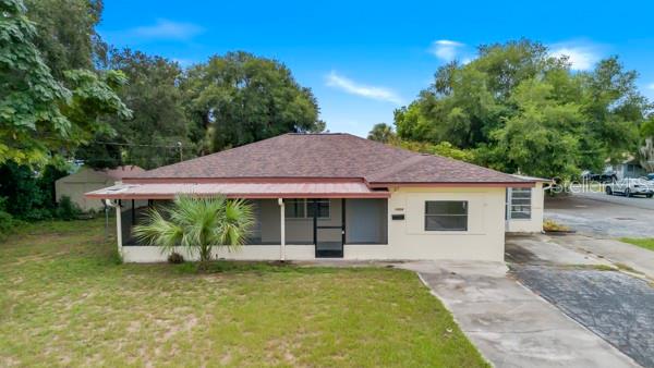 A single-story house with a brown shingled roof and a covered front porch — 1404 E ALFRED STREET, TAVARES, FL