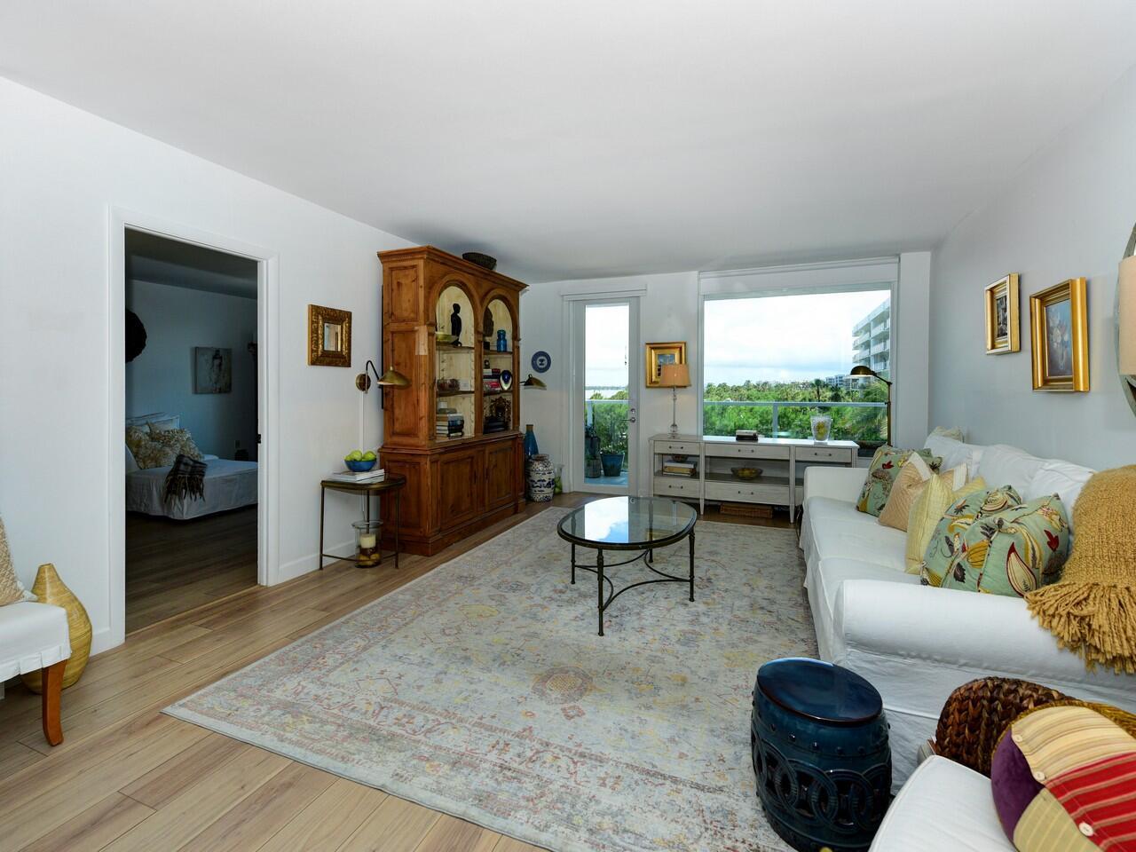 A living room features a white sofa, a wooden hutch, and a large window view — 3450 S Ocean Boulevard # 324, Palm Beach FL 33480, PALM BEACH, FL