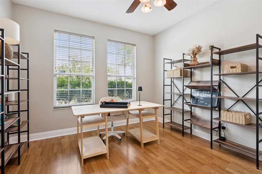 A home office features a wooden desk, two chairs, and three metal shelving units — 2563 WALNUT HEIGHTS ROAD, APOPKA, FL