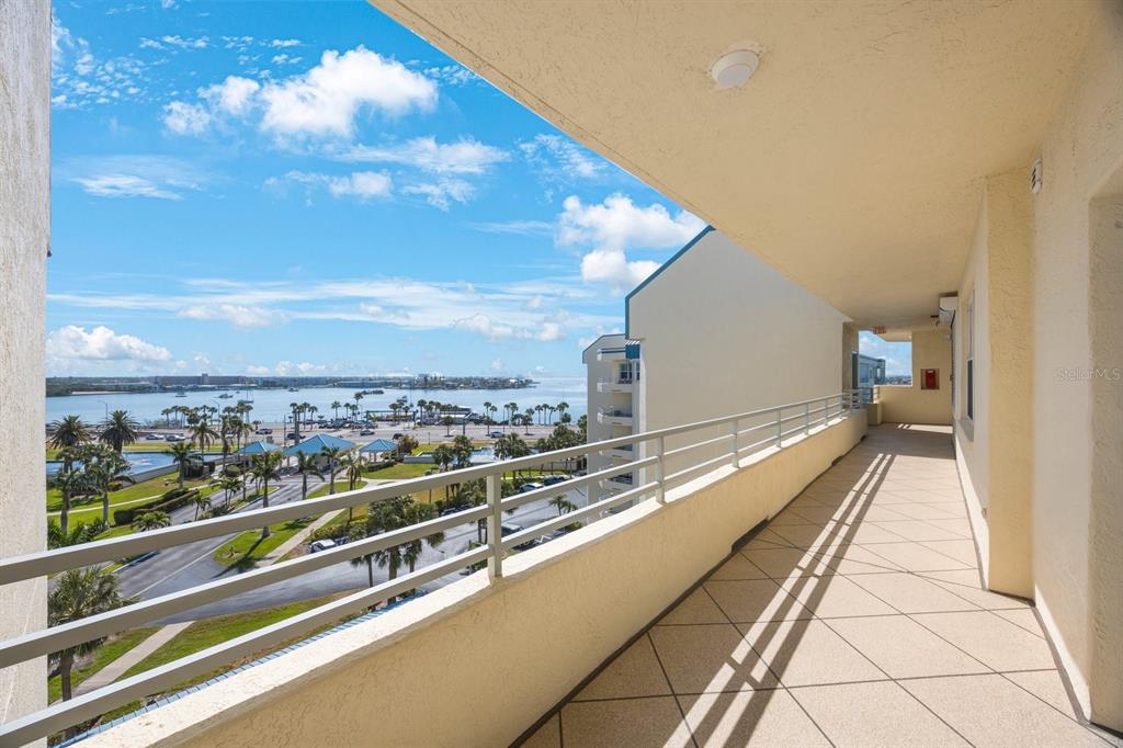 A covered balcony with a metal railing overlooks a parking lot and a bay — 7872 SAILBOAT KEY BOULEVARD S UNIT PH602, SOUTH PASADENA, FL