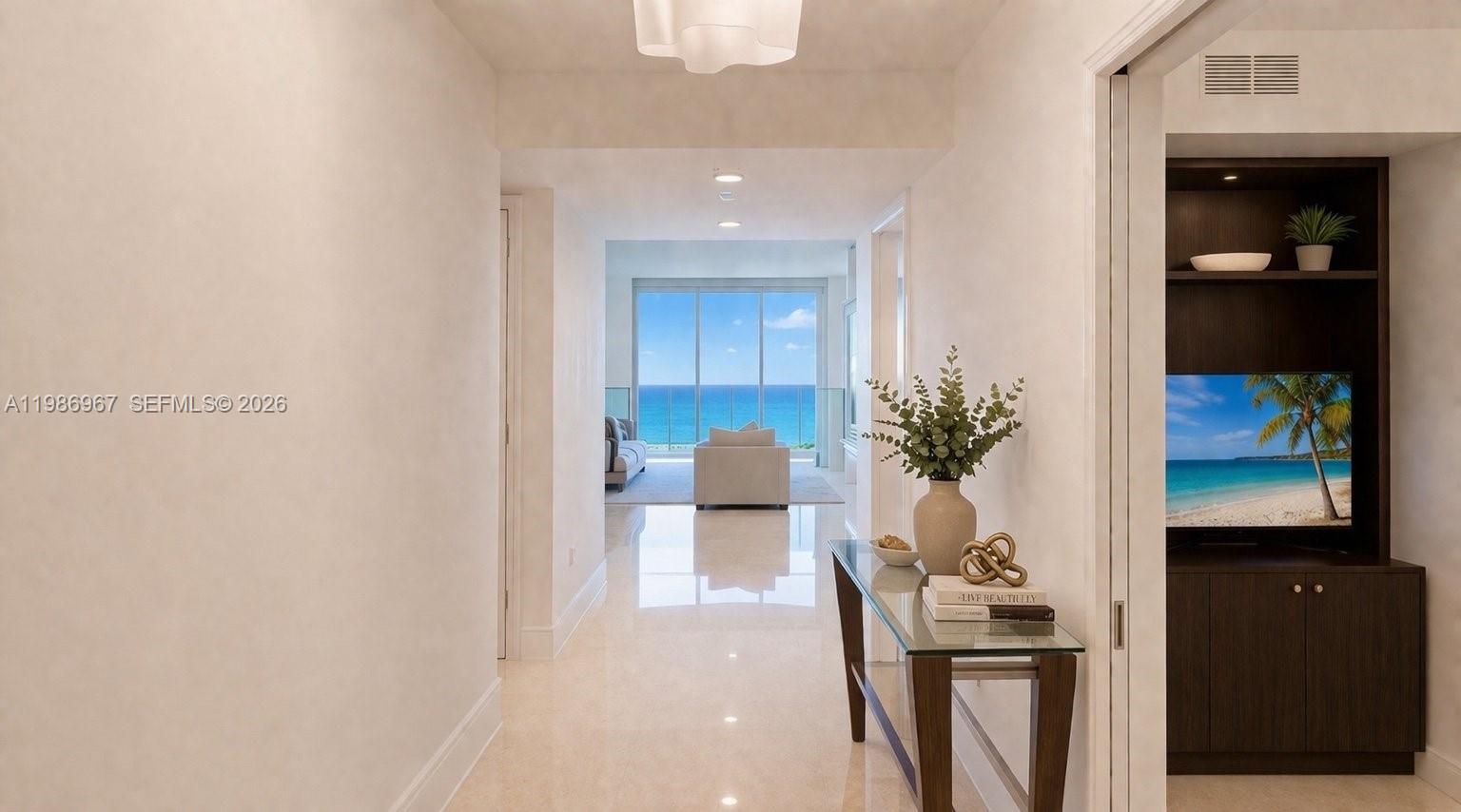 A hallway with a glass console table leads to a living area overlooking the ocean — 1800 S Ocean Dr, Hallandale Beach FL 33009, HALLANDALE BEACH, FL
