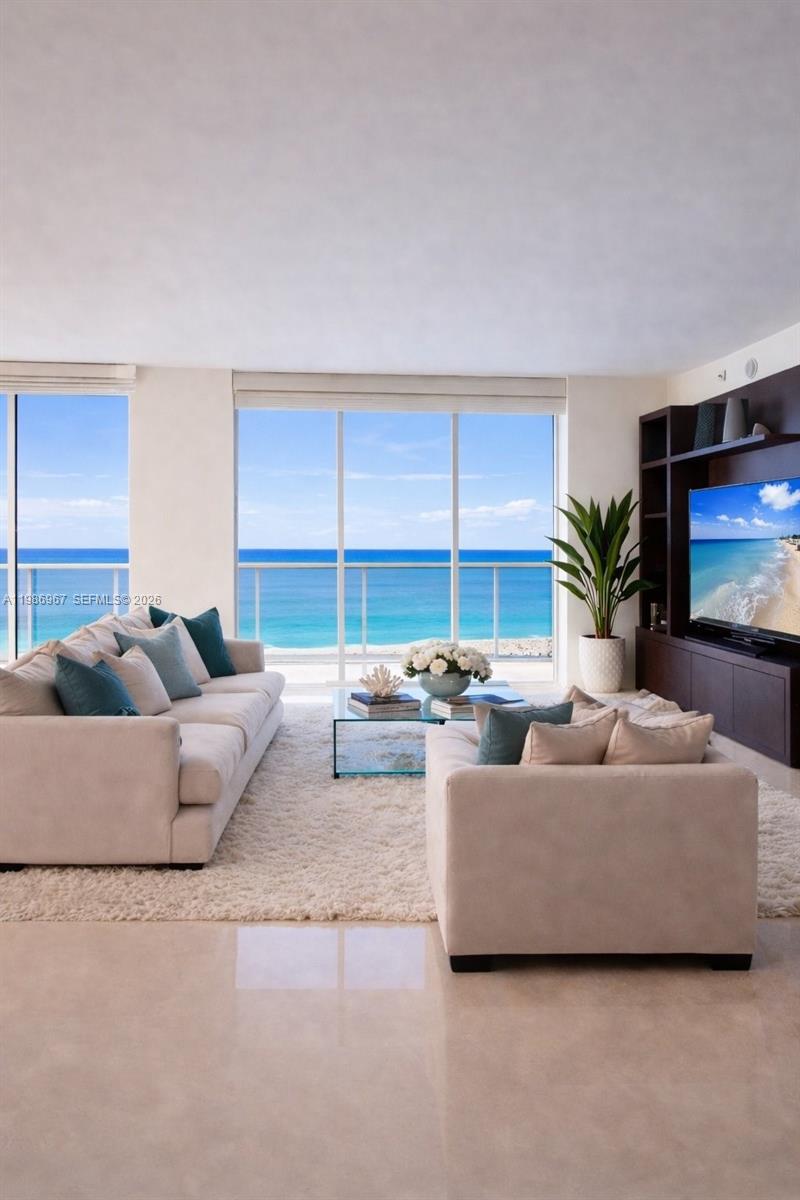 A living room features two beige sofas, a glass coffee table, and ocean views — 1800 S Ocean Dr, Hallandale Beach FL 33009, HALLANDALE BEACH, FL