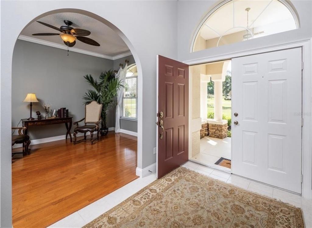 An entryway with a tile floor, a rug, and an arched opening to a room — 4541 NW 76TH COURT, OCALA, FL