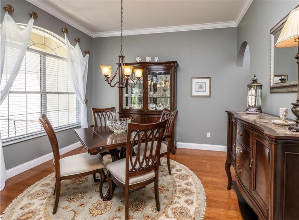 A dining room with a wooden table, chairs, hutch, and sideboard on a round rug — 4541 NW 76TH COURT, OCALA, FL