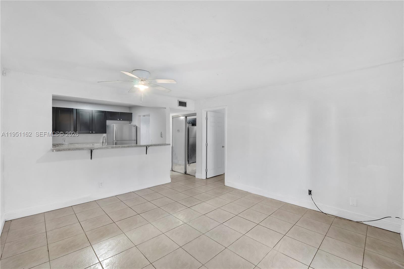 A living area with tile flooring features a kitchen pass-through and a ceiling fan — 4221 NW 19th St # 289, Lauderhill FL 33313, LAUDERHILL, FL