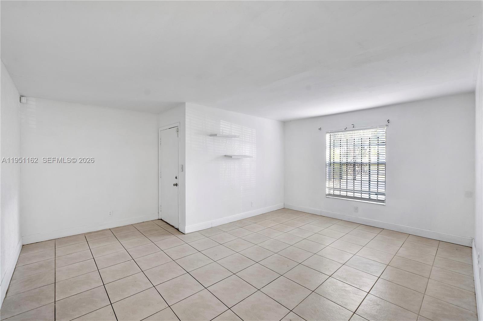 An empty room features white walls, light-colored floor tiles, and a single window with blinds — 4221 NW 19th St # 289, Lauderhill FL 33313, LAUDERHILL, FL