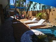 A backyard patio features a small pool, lounge chairs, and a blue shade sail — 2802 PASS A GRILLE WAY UNIT 2, ST PETERSBURG, FL