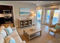 A living room with a sofa, coffee table, console, and an adjacent open kitchen — 2802 PASS A GRILLE WAY UNIT 2, ST PETERSBURG, FL